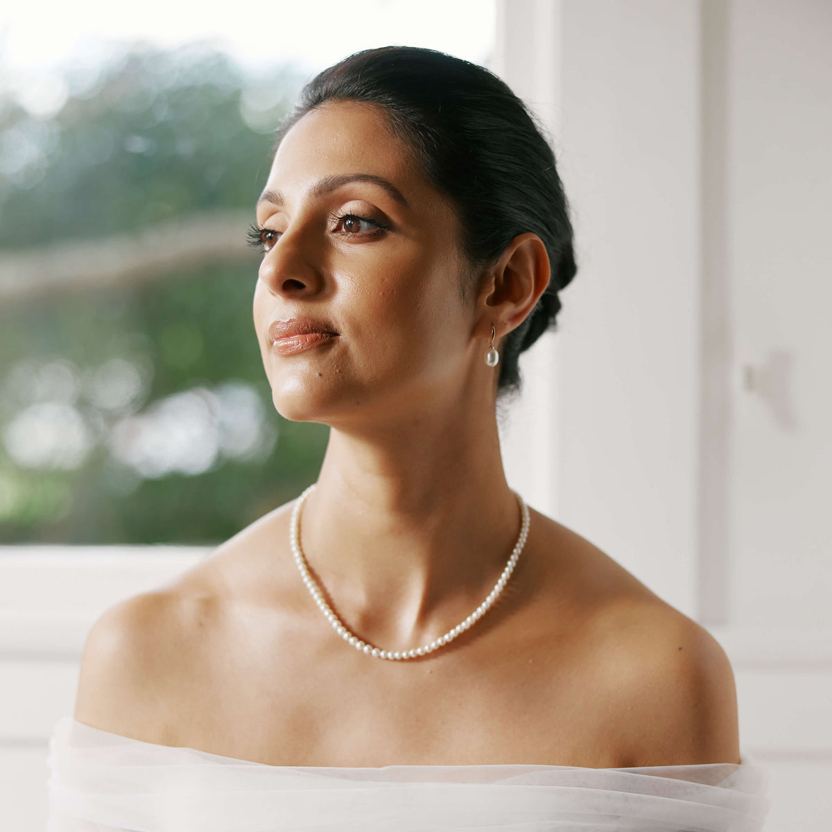 Bride wearing pearl necklace and pearl earrings