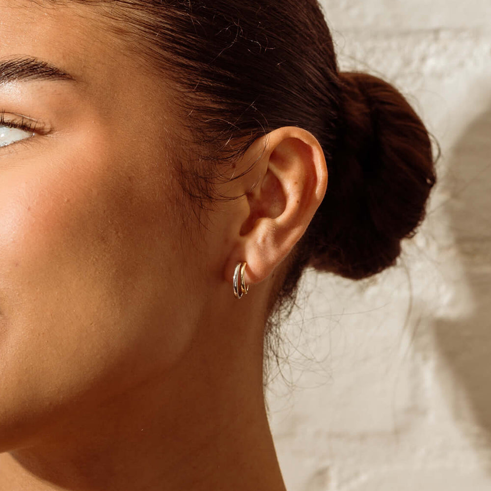 Close-up of a person wearing Gemma Earrings with a neutral background