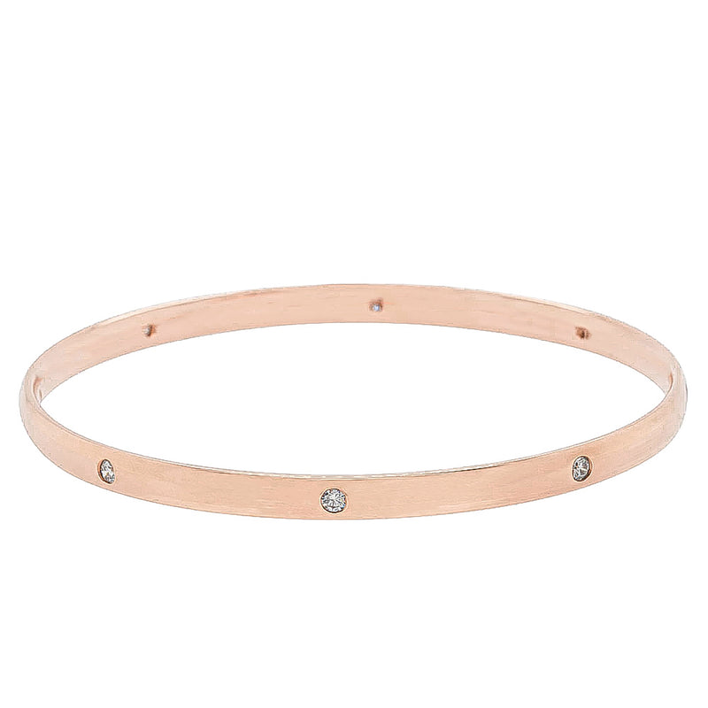 Rose gold bangle with embedded diamonds on a white background