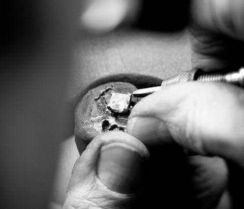 Jeweller setting a diamond into a ring