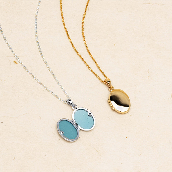 Sterling silver and Yellow gold lockets on neutral background