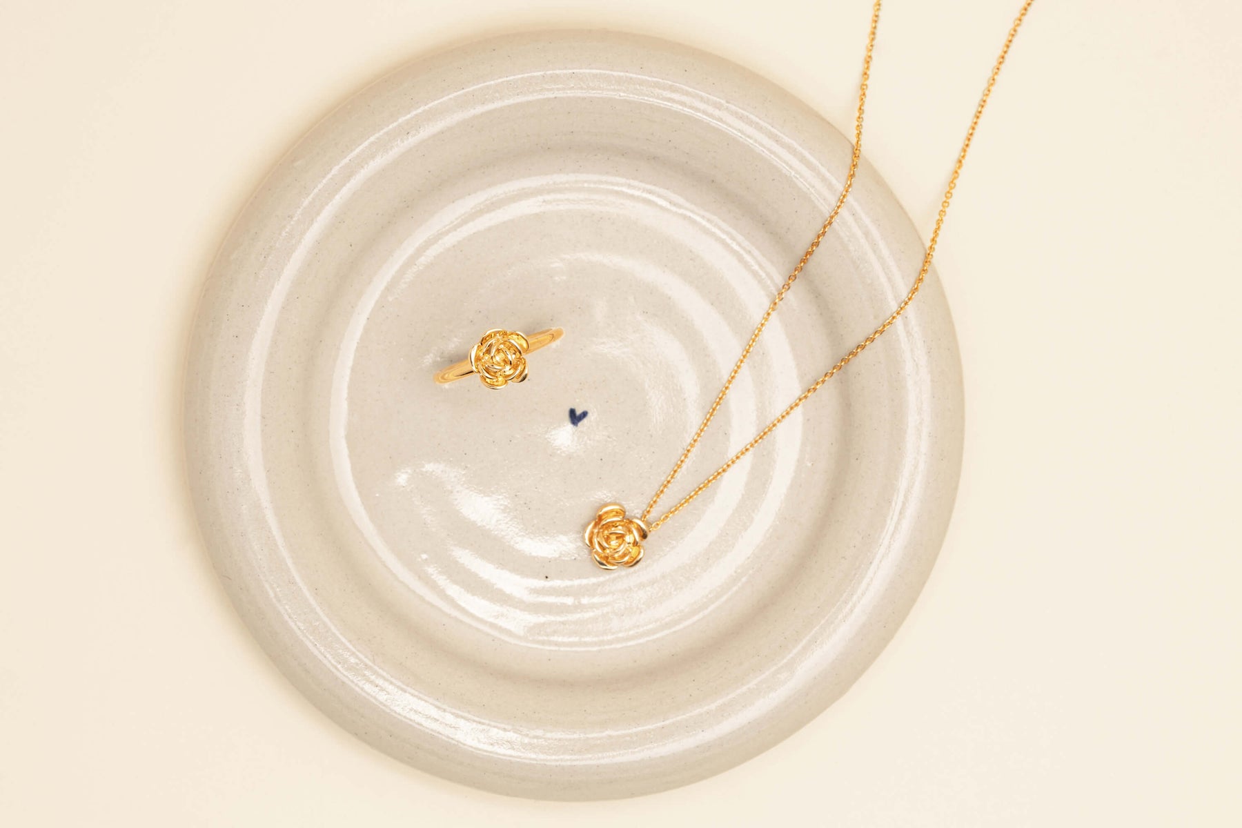 Yellow gold Albertine Rose Pendant and Ring resting in Walker & Hall x Agathe Ceramics Jewellery Dish