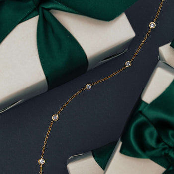 Diamond Natalia Bracelet on navy blue background with wrapped Walker & Hall gift boxes