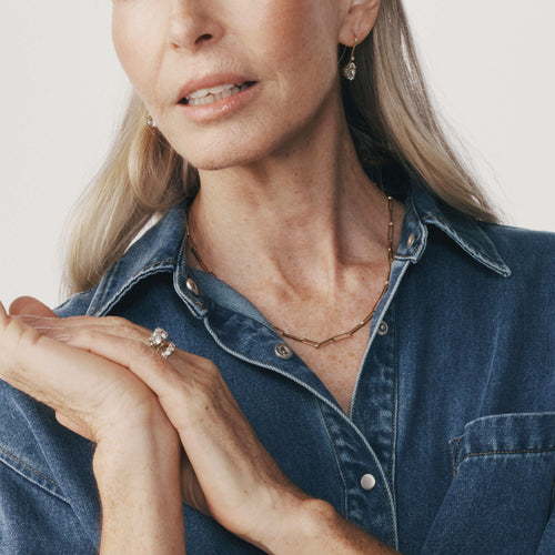 Model wearing recycled gold chain with denim shirt