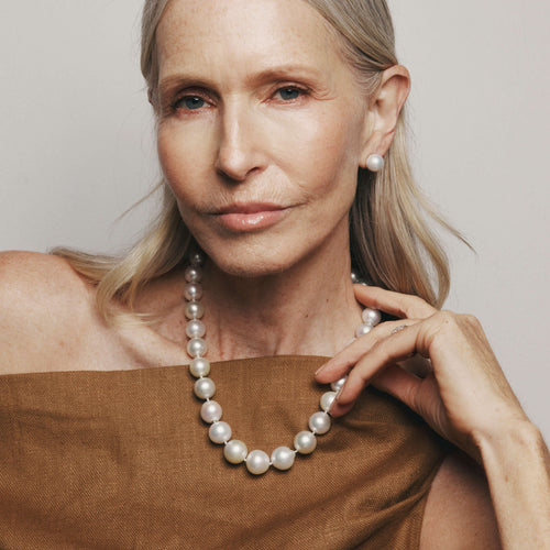 Model wearing pearl necklace and pearl studs