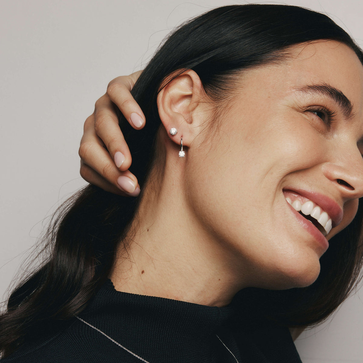 Woman smiling with a close-up of her ear wearing diamond Blossom Studs and Blossom Drop Earrings