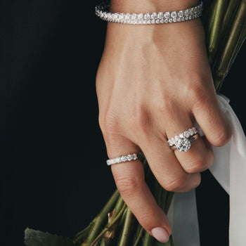 Close up of a hand wearing diamond rings and bracelets