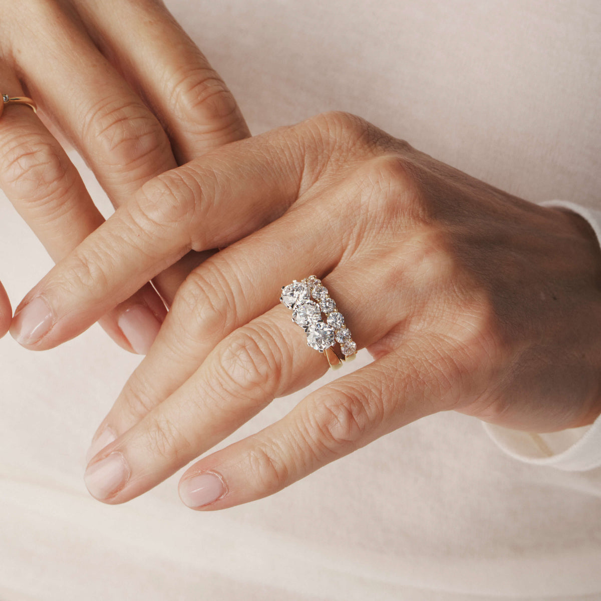 Close-up of hands wearing diamond Trilogy Ring