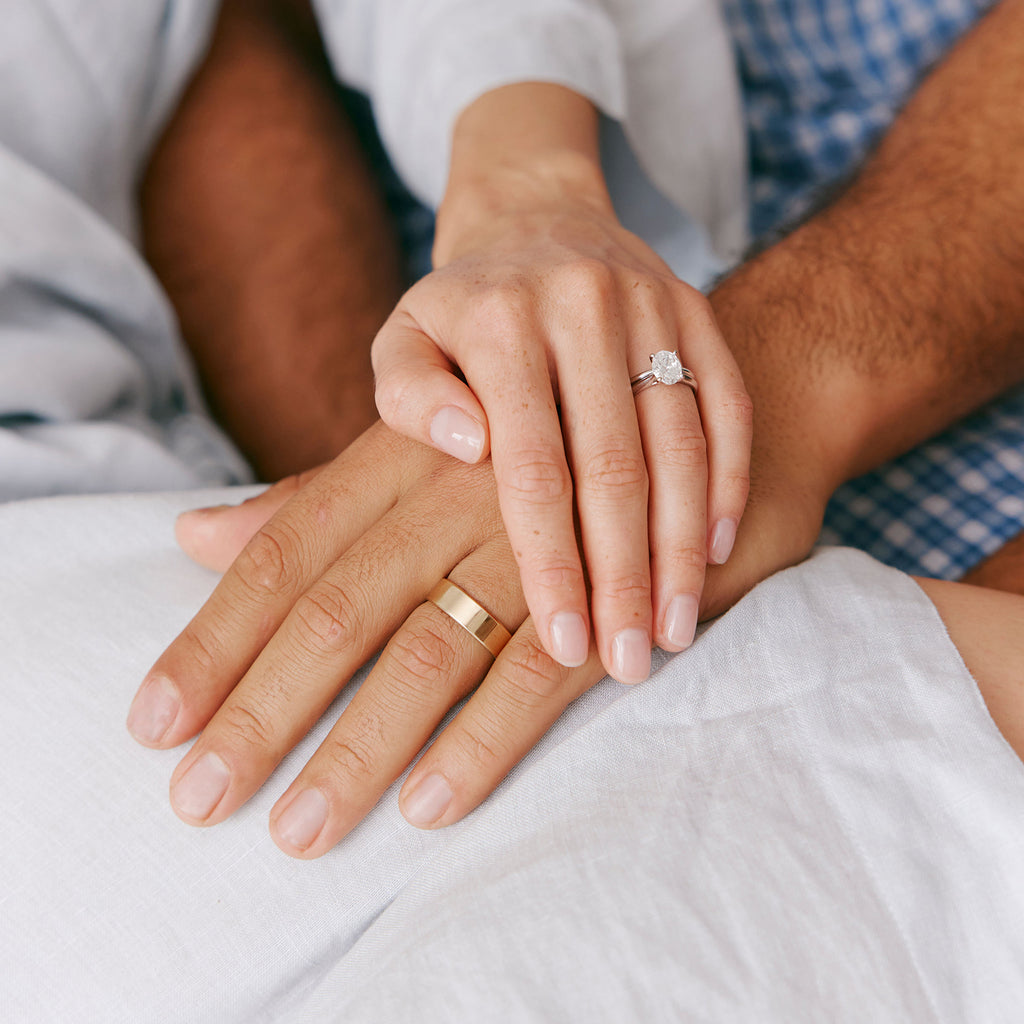 Couple holding hands wearing wedding rings